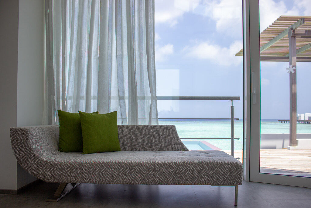 Sala luminosa con un sillón y cortinas claras