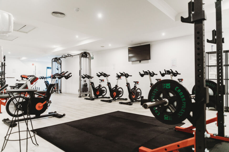 Sala de musculación con bicicletas y rack